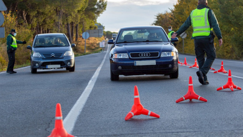 Un agente de la Guardia Civil detiene un vehículo