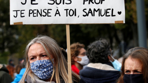 Una mujer sostiene una pancarta mientras asiste a un homenaje a Samuel Paty, el profesor de francés que fue decapitado en las calles del suburbio parisino de Conflans St Honorine, Francia. REUTERS / Pascal Rossignol / Archivo