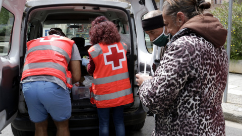 Voluntaris de la Creu Roja distribuint aliments als sensellar. ACN/Marina López