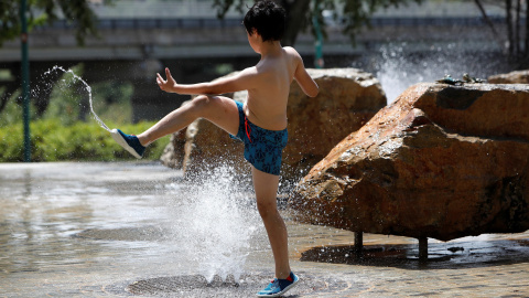 En la imagen, un niño juega en una fuente de la Avenida José Atares, Zaragoza | EFE