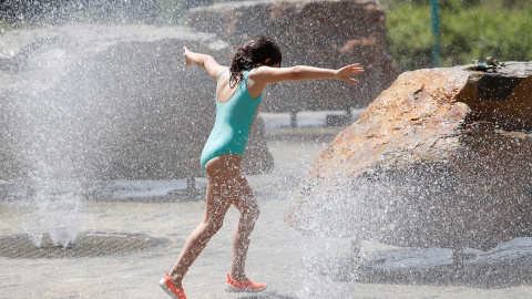 En la imagen, una niña juega en una fuente buscando refrescarse tras las altas temperaturas | EFE