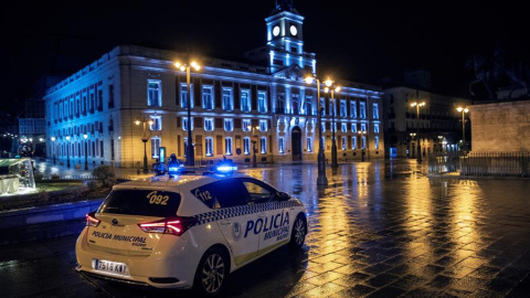 Un coche de la Policía Local vigila la Puerta del Sol anoche, primera jornada de toque de queda en la capital.