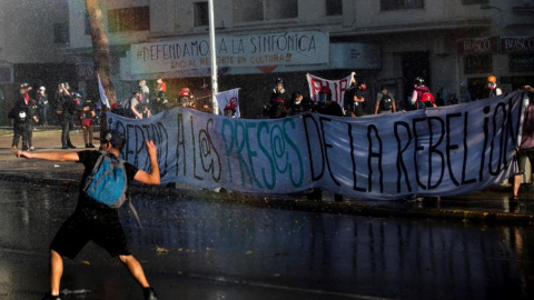 Manifestantes se enfrentan a los carabineros durante una nueva jornada de protestas en contra del gobierno del presidente de Chile, Sebastián Piñera, este viernes en Plaza Italia, ahora conocida como Plaza de la Dignidad, en Santiago. Con consignas a fa