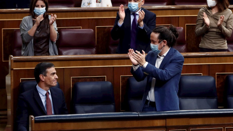 El presidente del Gobierno, Pedro Sánchez, es aplaudido por el vicepresidente segundo, Pablo Iglesias (d) y sus compañeros de partido tras su intervención en la moción de censura de VOX al gobierno de coalición, en el Congreso de los Diputados este m