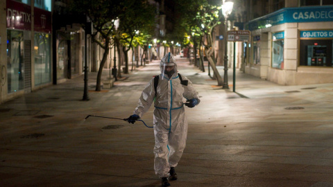 Un operario municipal realiza labores de desinfección, en la calle del Paseo de Ourense, en la madrugada de este martes. El Gobierno de España ha decretado el estado de alarma desde las 11pm. a las 6 am. para todo el territorio nacional, con posibilidad