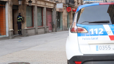 Un agente de la Policía Local de Salamanca vigila a las puertas de un local durante las labores de investigación de una "fiesta clandestina".