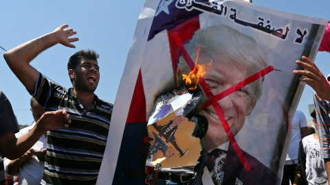 26/06/2019 - Palestinos queman una fotografía del presidente de EEUU, Donald Trump, como protesta contra la cumbre de Bahrein. / REUTERS - IBRAHEEM ABU MUSTAFA