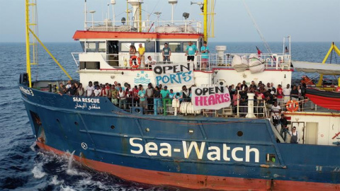 Migrantes esperan en la cubierta del barco de la ONG alemana Sea Watch, que continúa bloqueado este jueves ante las costas de la isla de Lampedusa. - EFE