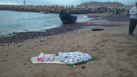 Imagen publicada por el portal 'le360.ma' en las que se ven varios cadáveres tapados con matas en una playa marroquí tras volar la patera con la que intentaban llegar a Canarias.