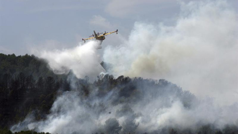 Imagen del incendio en La Pobla de Montornès (Tarragona) donde los Bomberos han desalojado hoy la parte alta de la urbanización Castell de Montornès como medida de precaución ante un incendio que arde sin control en una zona forestal de difícil acces