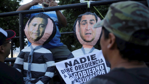 Fotografía de archivo fechada el 25 de octubre 2019 que muestra a manifestantes mientras cuelgan representaciones del presidente hondureño Juan Orlando Hernández (d) y su hermano Juan Antonio "Tony" Hernández (i) durante una protesta en Tegucigalpa (H