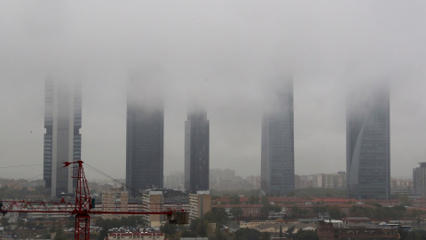 Vista de la lluvia y la niebla entre el complejo de las Cuatro Torres de Madrid a primera hora de la mañana.