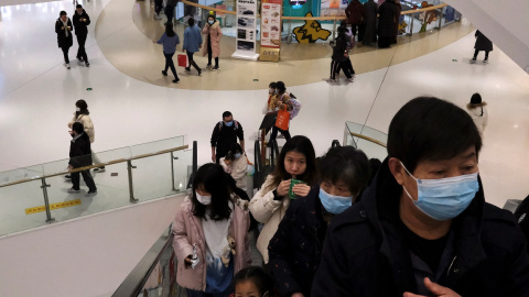 Varias personas, en una escalera mecánica en un centro comercial en Pekín. REUTERS/Tingshu Wang