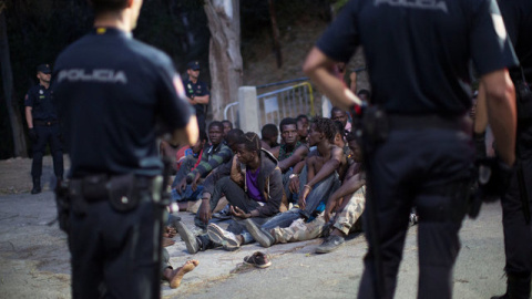 La Policía frente al grupo de migrantes después de saltar la valla de Ceuta / REUTERS