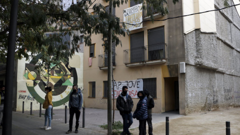 Diverses persones davant d'un bloc ocupat per joves a Manresa.