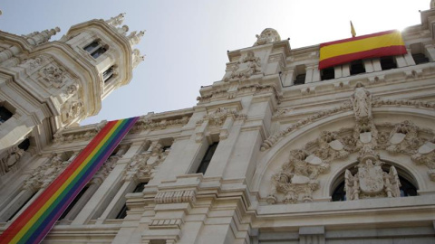 Vista de la bandera arcoirís del colectivo LGTBI (izquierda), que ha sido instalada este viernes en la fachada del Ayuntamiento de Madrid, junto a una bandera de España (derecha). /EFE