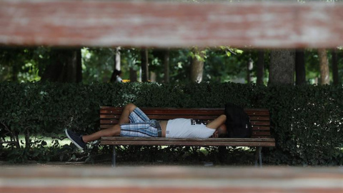 27/06/2019.- Un hombre descansa en un banco del parque de El Retiro, en Madrid. EFE/Juan Carlos Hidalgo