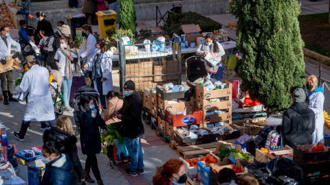 18/01/2022-Personas en riesgo de exclusión acuden a recoger alimentos, en la plaza de San Amaro, a 7 de enero de 2022, en Madrid (España).