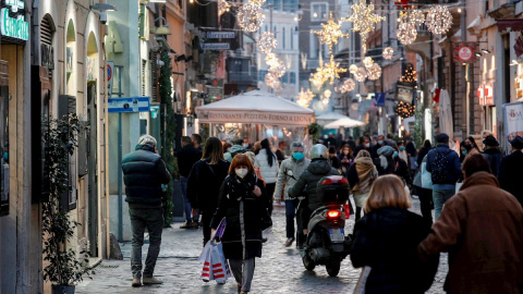 Transeúntes pasean por una calle de Roma, Italia