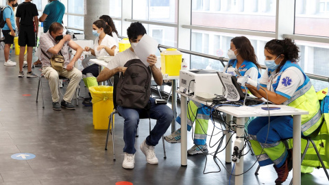 Varias personas reciben la vacuna contra la covid en el punto de vacunación masivo instalado en el Wizink Center de Madrid.