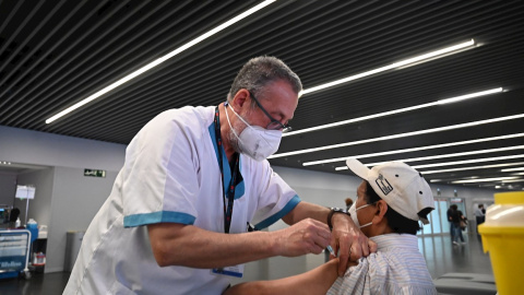 Un sanitario vacuna a una persona en el estadio Wanda Metropolitano en Madrid, que acoge este martes el inicio de la vacunación con Astrazeneca para la población general de 60 a 65 años, que toman el relevo de los mayores de 80 años que viven en sus d