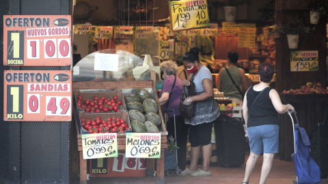 Varias personas compran en una frutería.