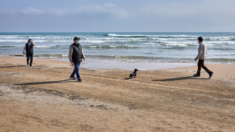 Varias personas pasean por la playa de Gandía, València.