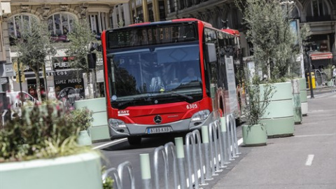 Un autobús de la línea C1 pasa al lado de los maceteros colocados en la Plaza del Ayuntamiento de Valencia.