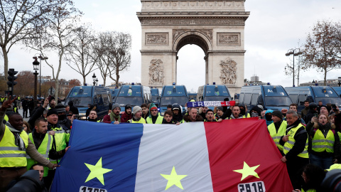 Manifestantes de los chalecos amarillos portan una bandera de Francia con tres fechas señaladas en cada franja: 1789, 1968 y 2018. REUTERS/Benoit Tessier