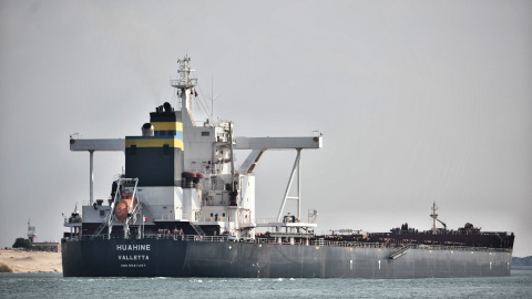 Un barco navega por el Canal de Suez mientras el tráfico se reanuda después de que el buque portacontenedores "Ever Given" operado por Evergreen Marine Corporation fuera liberado tras bloquear la ruta fluvial durante casi una semana.