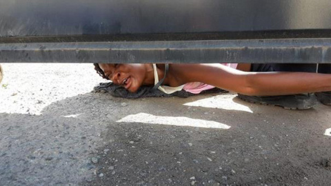 Una mujer haitiana pide ayuda para ella y su hijo desde el interior del albergue Siglo XXI en la ciudad de Tapachula, en el estado de Chiapas (México). - EFE