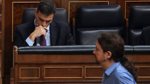 El líder de Podemos, Pablo Iglesias, pasa ante el jefe del Ejecutivo, Pedro Sánchez, durante el pleno del Congreso. (BALLESTEROS | EFE)