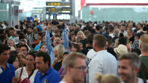 Un hombre toma una foto con su smartphone de las largas colas de pasajeros en los controles de seguridad del aeropuerto de Barcelona-El Prat, en la primera jornada de paros de los trabajadores de Eulen, encargada de este servicio. REUTERS/Albert Gea