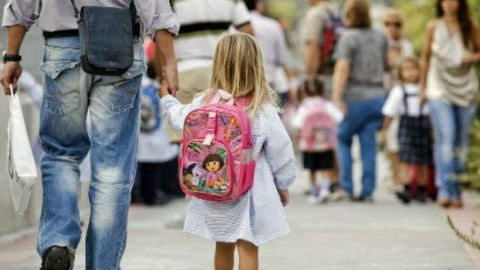 Un padre lleva de la mano a su hija en una calle de Madrid./EFE