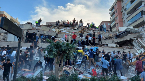 Vecinos ayudan en las labores de búsqueda de supervivientes entre los escombros de los edificios derrumbados por el terremoto que ha sacudido Izmir (Turquía).