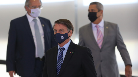 EL presidente Jair Bolsonaro con Paulo Guedes (izq), ministro de economía, y el general Braga Netto, nuevo ministro de defensa, en un reciente acto del Gobierno brasileño. FÁBIO RODRIGUES POZZEBOM/ AGÊNCIA BRASIL. 19MAR21.