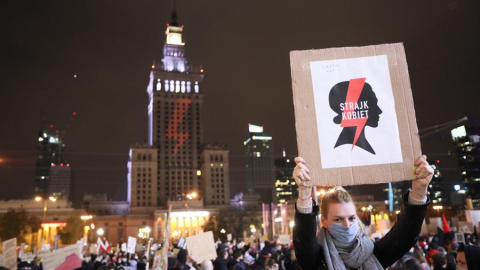 Una mujer sostiene una pancarta que dice 'Huelga de mujeres' mientras la gente participa en una protesta contra el endurecimiento de la ley de aborto en Varsovia, Polonia, el 30 de octubre de 2020.El Tribunal Constitucional de Polonia dictaminó el 22 de 