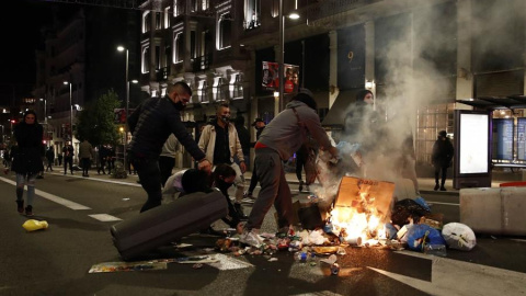 Varios participantes en las protestas convocadas esta noche incendian cubos de basura en la Gran Via de Madrid, por las medidas tomadas tras el aumento de contagios por coronavirus.