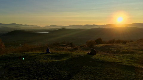 Dos mujeres ven amanecer desde la cima del cerro Olarizu en Vitoria este sábado 31 de octubre. - EFE