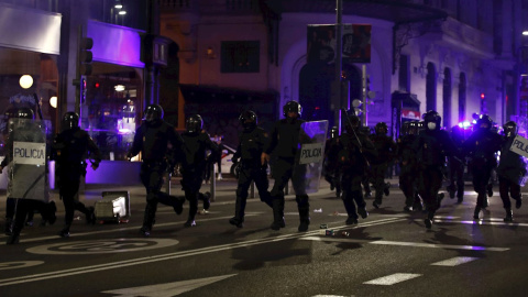 Miembros de la Policía Nacional recorren la Gran Via de Madrid durante los disturbios.