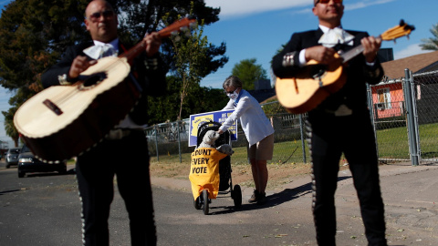 Una mujer atiende a su perro en un carrito con las palabras "cuenta todos los votos" mientras tocan los mariachis, durante un evento para promover la importancia del voto latino y el apoyo al candidato demócrata de Estados Unidos Joe Biden, en el vecinda