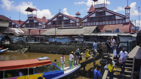 Un grupo de personas desciende de un barco en el muelle de Georgetown, la capital de Guyana