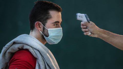 Imagen de un hombre mientras le toman la temperatura