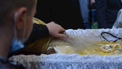 Un joven rinde homenaje durante el funeral del obispo metropolitano de la Iglesia Ortodoxa Serbia de Montenegro.