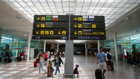 Viajeros junto a uno de los paneles informativos del Aeropuerto Barcelona-El Prat. REUTERS/Albert Gea