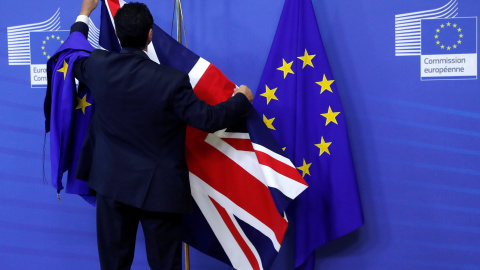 Un empleado de la Comisión Europea coloca las banderas de la UE y del Reino Unido en la sede de institución comunitaria con motivo de la primera reunión para la negociación del Brexit, el pasado 17 de julio, en Bruselas. REUTERS/Yves Herman