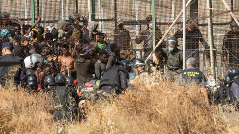 29/06/2022 Un miembro de las fuerzas de seguridad marroquí se lleva detenido a un migrante desde el lado español de la frontera con Melilla