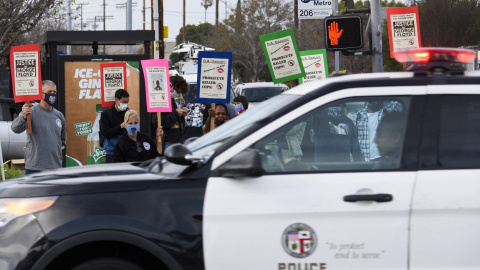 Un coche de la Policía de Los Ángeles pasa junto a una protesta por las muertes de George Floyd y Daunte Wright, a 12 de abril de 2021.