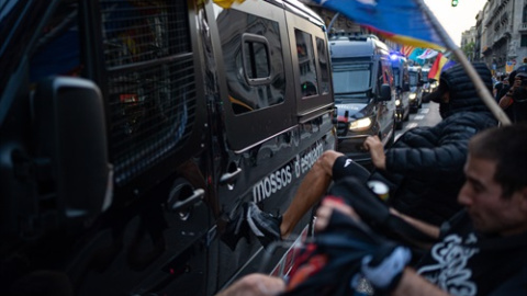 Varios hombres patean un furgón de los Mossos durante los altercados en la comisaría de la Policía Nacional de la via Laietana tras la manifestación de la ANC por la Diada, día de Cataluña, a 11 de septiembre de 2021, en Barcelona, Catalunya