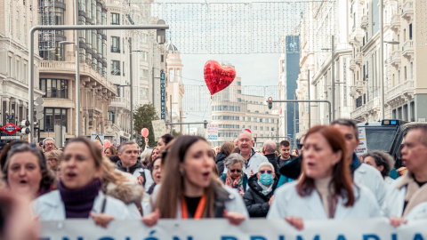 Varias personas caminan con pancartas y un globo en el que pone 'Atención primaria' durante una manifestación de médicos y pediatras desde la Consejería de Sanidad hasta la sede del Gobierno regional, a 30 de noviembre de 2022, en Madrid (España).